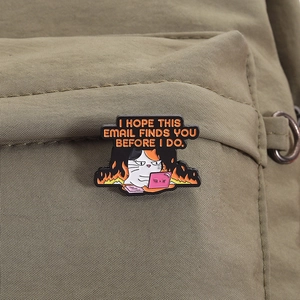 Detail of funny calico cat laptop enamel pin badge on a military green canvas backpack