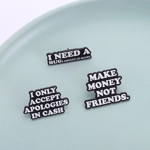 Lot de trois broches en émail noir avec des citations humoristiques au design moderne