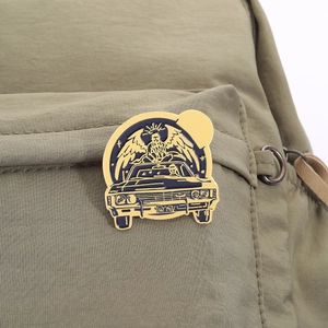 Detaillierte Nahaufnahme einer Vintage-Auto-Emaille-Anstecknadel an einem Rucksack
