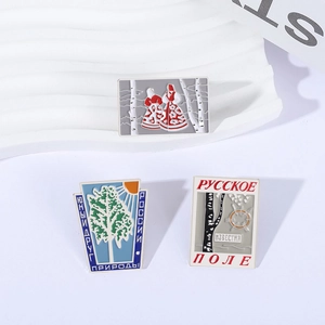 Geometric enamel pins featuring Russian birch trees and folk art on a white pedestal
