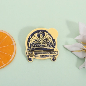 Golden enamel pin featuring a vintage muscle car with a winged angel and KAZ 2Y5 plate
