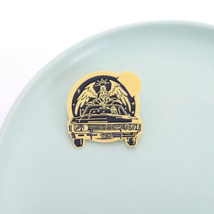 Golden enamel brooch featuring a blue vintage muscle car and winged angel character