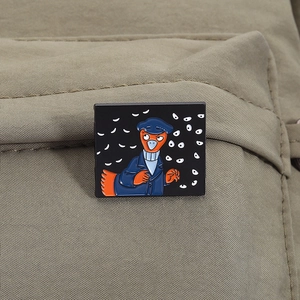 Close-up of a detective duck enamel pin on green canvas fabric background