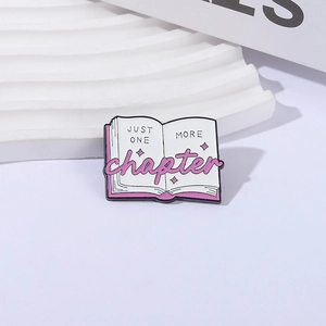 Cartoon open book enamel pin with Just One More Chapter text for readers and book lovers