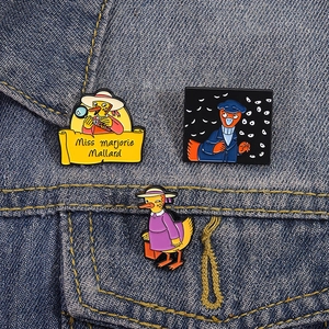 Three detective duck enamel pins featuring Miss Marjorie Mallard on blue denim fabric
