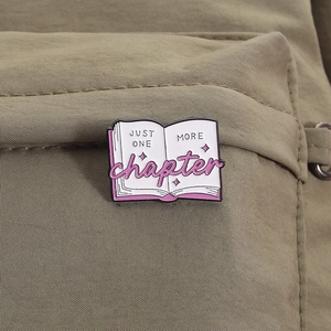 Detail of enamel book brooch with Just One More Chapter text on a canvas bag