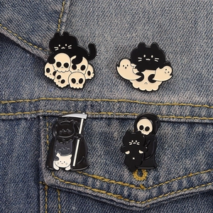 Set of four spooky Halloween black cat enamel pins with skull and reaper motifs on denim jacket