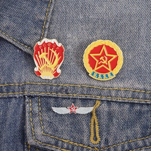 Macro-opname van drie Sovjet emaille badges op een donkerblauwe denim stof