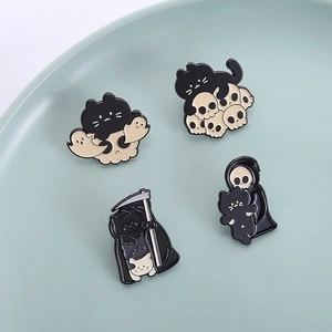 Halloween enamel pin set with black cat, skeleton and grim reaper motifs on ceramic plate