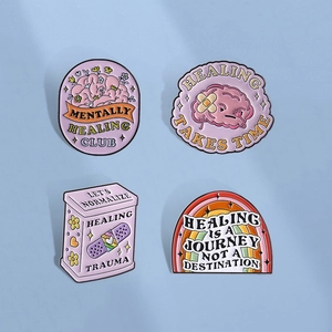 Set of four pink enamel pins featuring brain and mental health healing designs