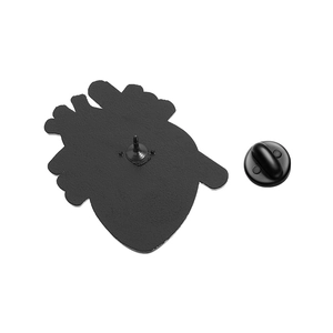 Detailed back view of anatomical heart metal badge with black pin and butterfly clutch