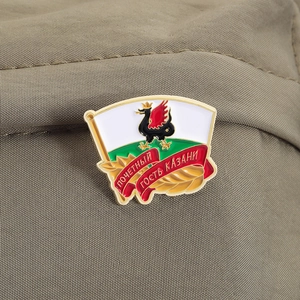 Gros plan détaillé du badge souvenir Kazan Zilant avec finition émail sur tissu vert olive