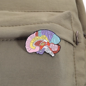 Détail macro du pin's émaillé anatomie du cerveau coloré sur un sac en toile olive