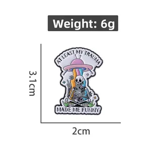 Funny skeleton UFO enamel pin with At Least My Trauma Made Me Funny quote, 3.1x2cm