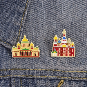Detailed close-up of Russian landmark enamel pins on dark blue denim fabric texture
