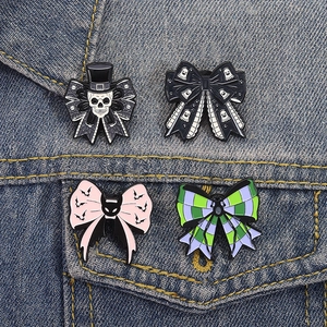 Gothic Halloween enamel bow brooches with skull and bat motifs on a denim jacket