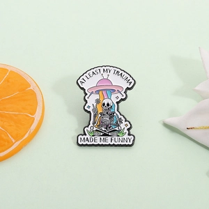 Funny skull and UFO enamel pin badge with 'At least my trauma made me funny' quote