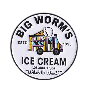Round white enamel pin featuring a colorful cartoon ice cream truck with geometric letters