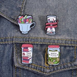Set of four creative enamel book lover pins featuring tea cup and hourglass on denim