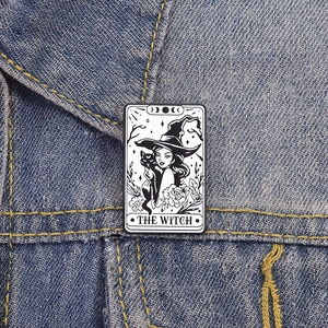 Tarot style enamel pin featuring a witch and black cat on denim jacket collar