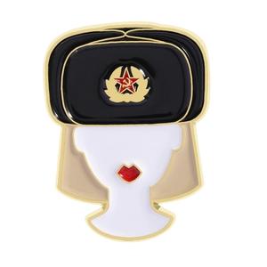 Macro detail of enamel brooch showing Russian doll with Soviet star on a winter hat