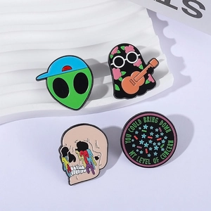Set of four unique enamel pins featuring alien, ghost, skull, and creative slogan designs