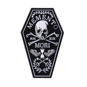 Coffin-shaped Memento Mori enamel pin with skull and hourglass on white background