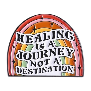 Rainbow enamel brooch with Healing is a Journey quote and black star patterns