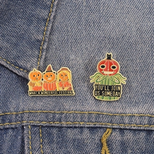 Halloween enamel pumpkin pins with festive phrases on a classic blue denim jacket
