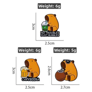Three-piece set of cartoon capybara enamel pins showing sizes and weights on white background