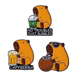 Three cute capybara enamel pins with Capybeera puns and bubble tea on white background