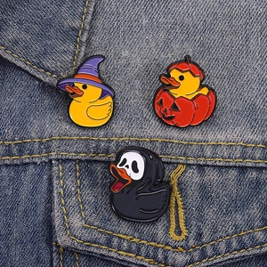 Cartoon Halloween duck enamel pin set with wizard hat, pumpkin, and ghost mask on denim