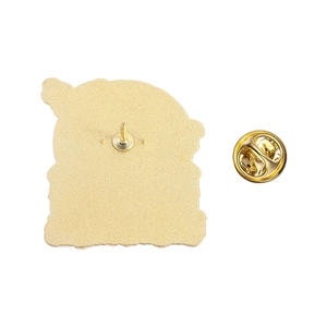 Macro detail of golden metal brooch back with sandblasted texture and butterfly clutch