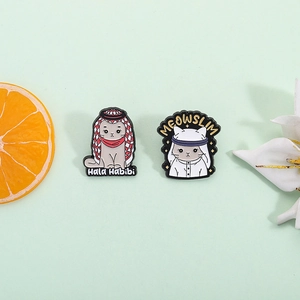 Cartoon enamel cat pins with headscarves featuring Hala Habibi and Meowslim slogans