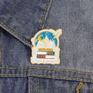 Macro shot of mountain and moon enamel pin pinned on a classic blue denim jacket lapel