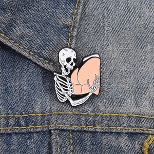 Funny Halloween skeleton holding butt enamel pin on denim jacket collar