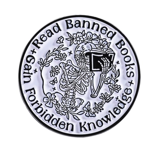 Skull reading banned books enamel pin with detailed floral and butterfly patterns