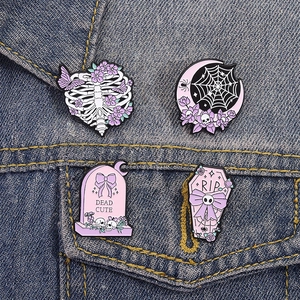 Set of four gothic Halloween enamel pins featuring moon spiderweb and coffin on denim fabric