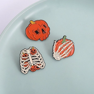 Tre spille smaltate di Halloween con teschi e zucche su un piatto decorativo in ceramica