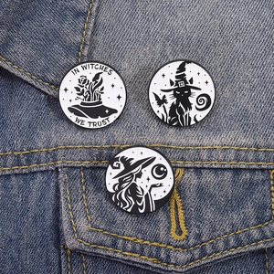 Detailansicht der schwarz-weißen Zaubererkatze- und Mond-Emaille-Pins auf Denim