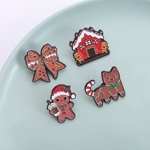 Lot de pins émaillés de Noël avec maison en pain d'épices, chat et nœud sur plateau céramique