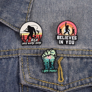 Funny Bigfoot enamel pin set featuring fishing and outdoor quotes on denim jacket