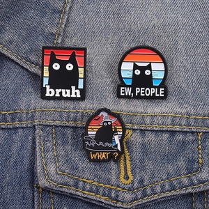 Trois pin's chat noir émaillés avec soleil couchant rétro sur veste en jean bleu