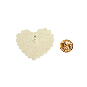 Macro shot of gold heart-shaped brooch back with anti-slip texture and butterfly clutch