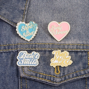 Set of four colorful enamel heart and letter pins on denim jacket decoration
