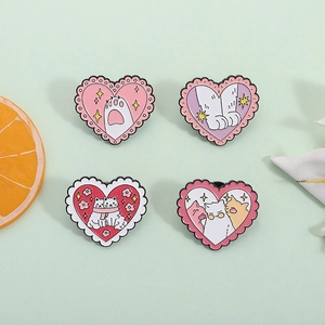 Set of four cartoon pink heart-shaped enamel cat pins on a fresh green background