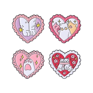 Set of four cute heart-shaped enamel pins featuring cat paws and stars on white background