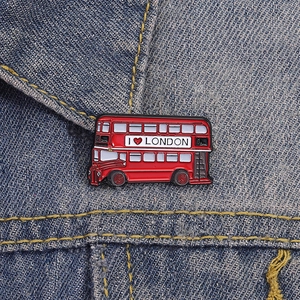 Broche émaillée bus à impériale rouge de Londres épinglée sur veste en jean