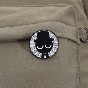 Makro-Detail einer runden Sprunki-Emaille-Anstecknadel mit Cartoon-Motiv an einer Tasche