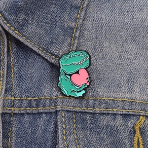 Niedliche grüne Emaille-Dinosaurier-Brosche mit Herz an einem Denim-Kragen